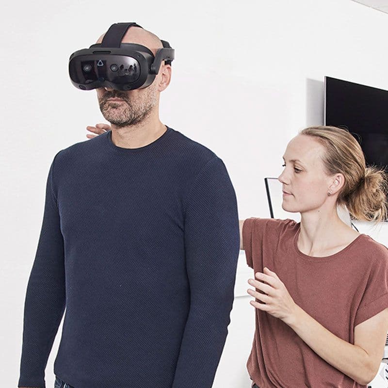 En audiolog hjælper en patient med en BalanceVR-genoptræningsøvelse.